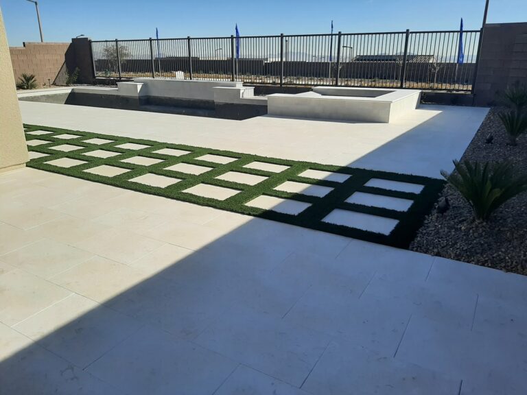 Travertine pool deck with turf strips and rock planting beds
