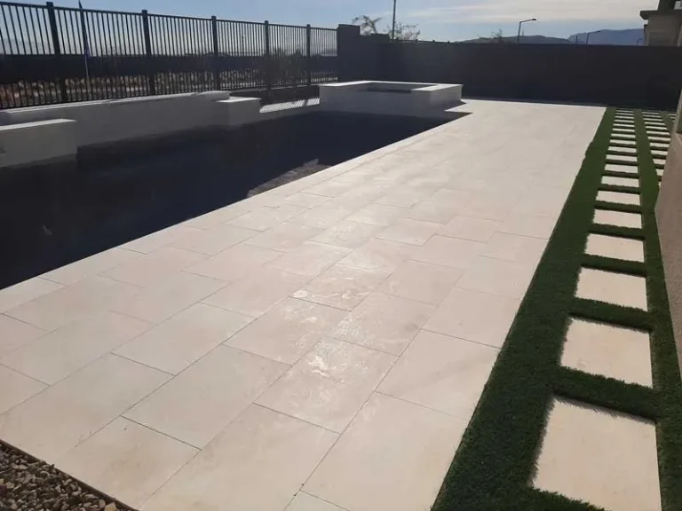 Travertine pool deck with turf stepping-stone strip in a Las Vegas backyard