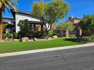 front yard landscaping with lush green turf, ornamental trees and decorative rock beds in Las Vegas Nevada by FreshStart Landscaping