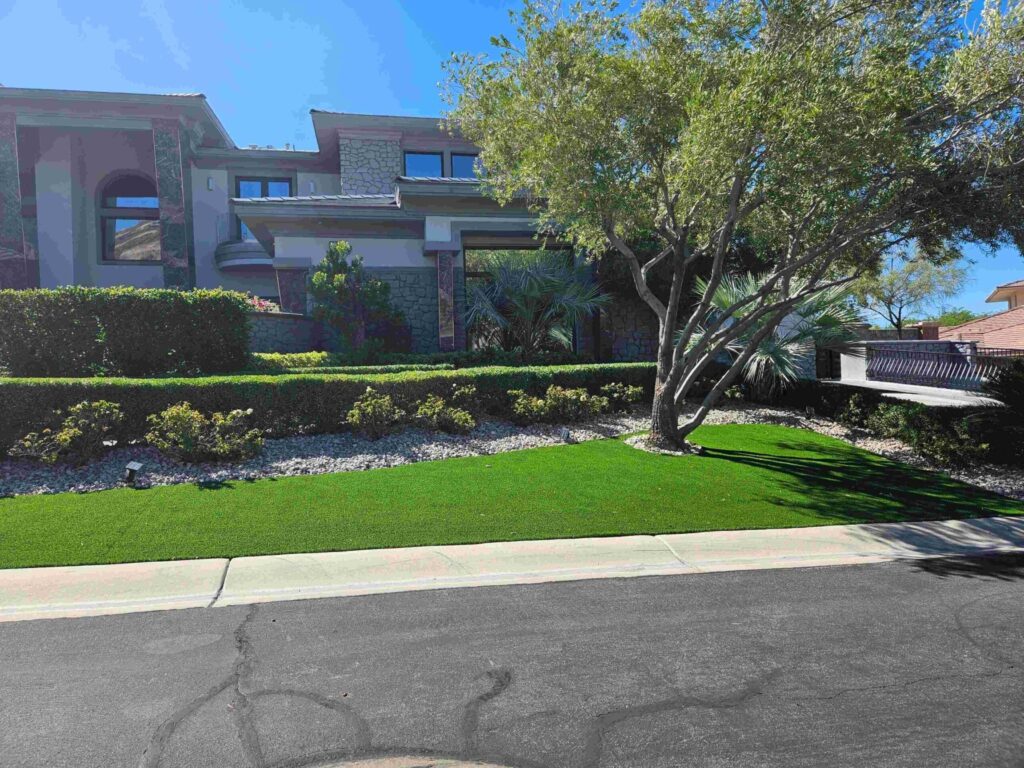 Front yard with artificial turf, shade tree and desert planting beds in Las Vegas