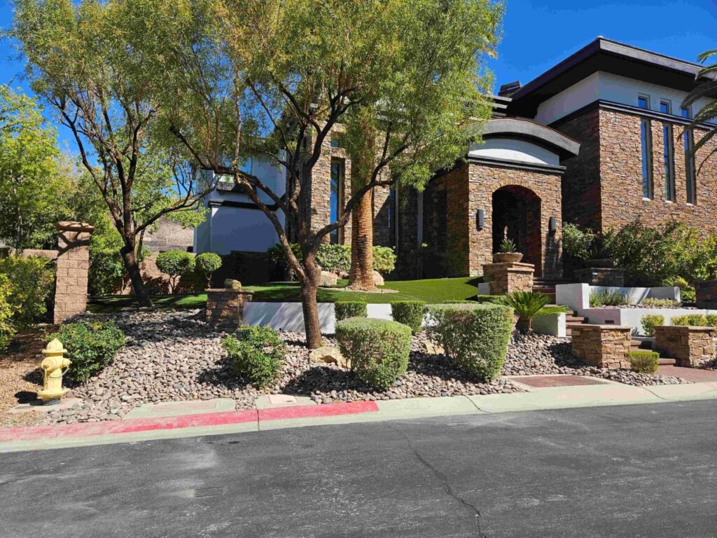 Desert front yard with shade trees, rock beds and low-water shrubs in Las Vegas