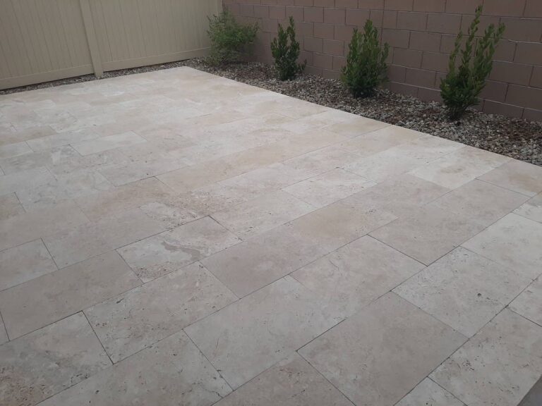 Ivory travertine paver patio against block walls in a Las Vegas backyard by FreshStart Landscaping