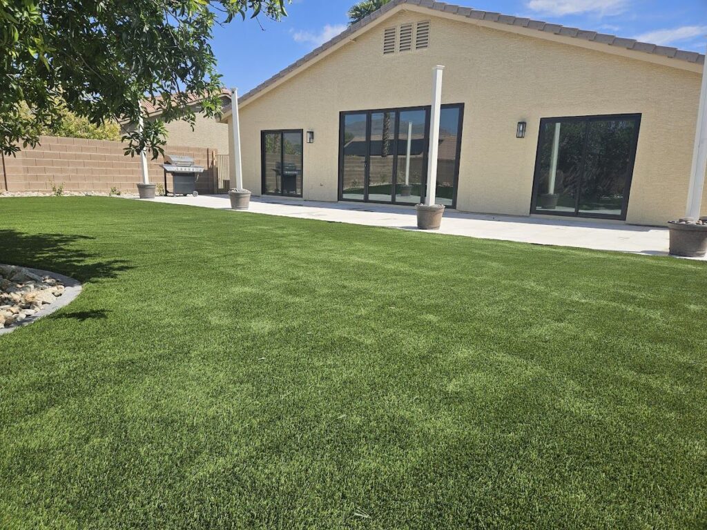 Modern Las Vegas backyard with artificial turf lawn and covered patio installed by FreshStart Landscaping